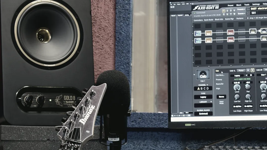 The control desk with a guitar neck resting across it, a rack processor and the studio monitor beside the screen.